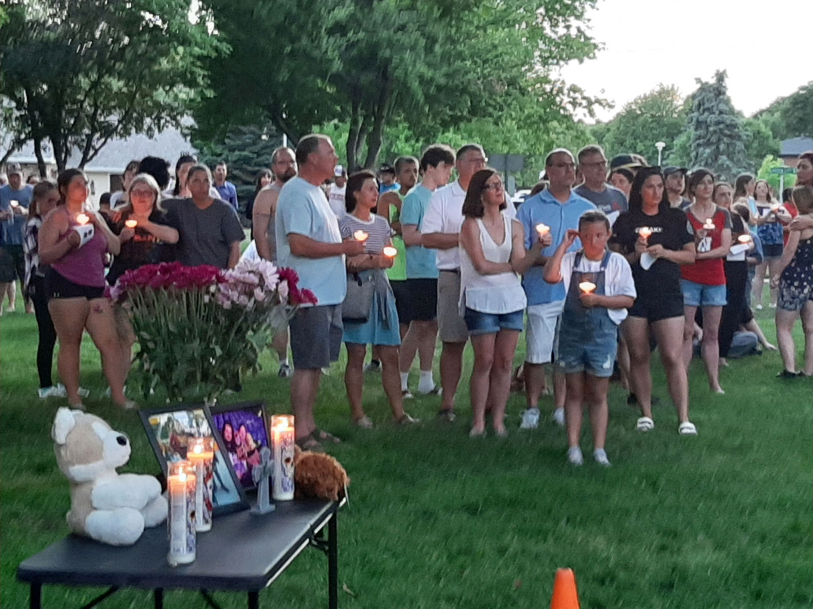 People listen during candlelight vigil